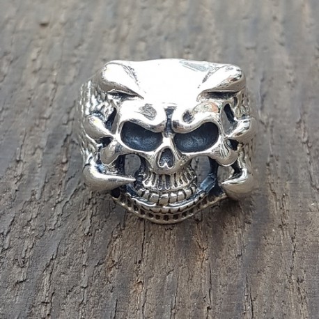 bague argent 925 tete de mortavec en son centre un crane et de chaque coté des griffes qui viennent enlacé celui-ci .